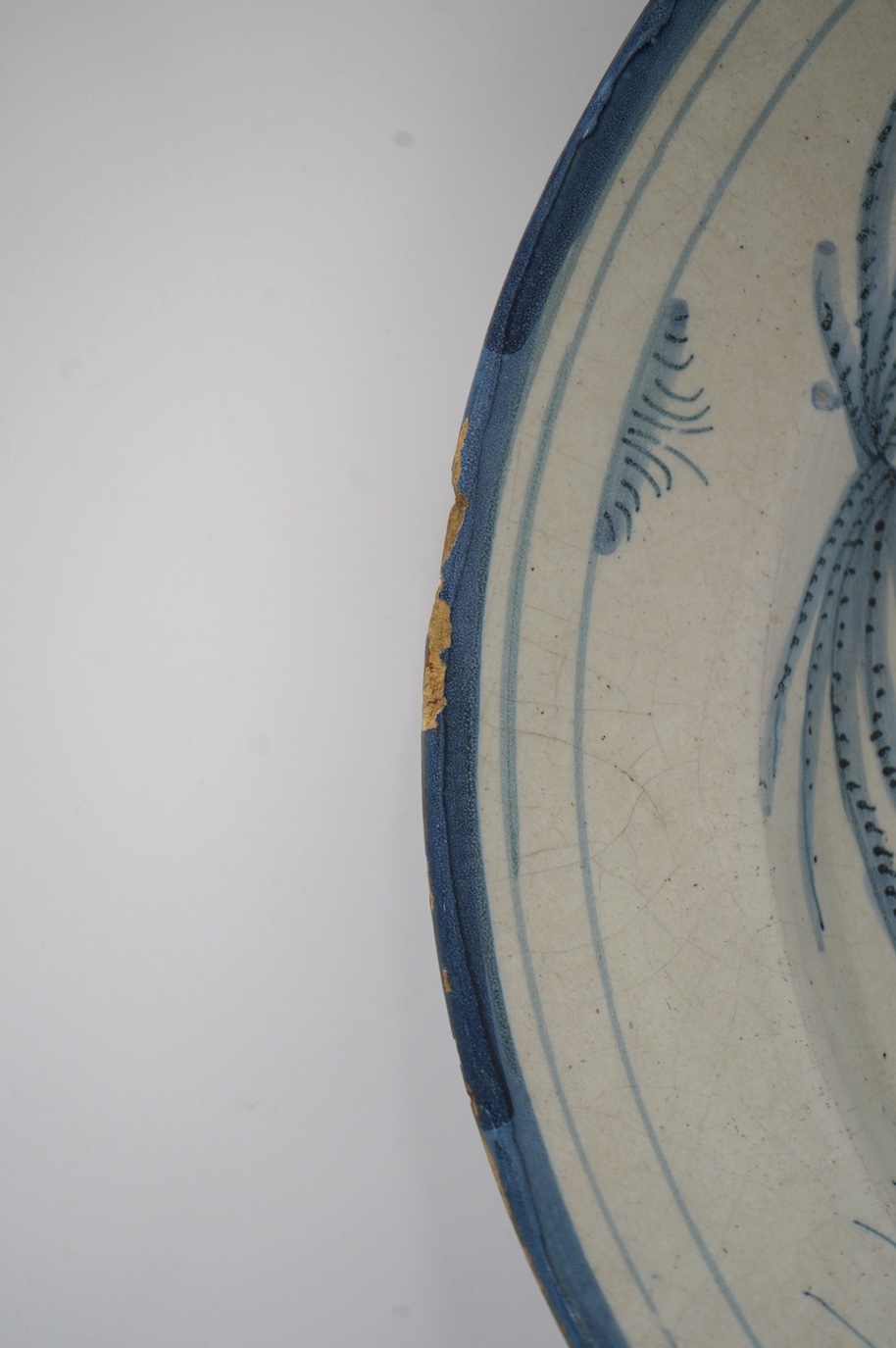 An 18th century Dutch Delft blue and white charger, diameter 33.5cm. Condition - poor, large crack running across half the diameter of the plate and through to the base, as well as some chips to the rim including one lar